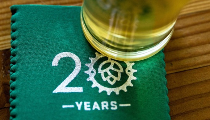 Real Ale Logo on 20th Anniversary koozie under an ice cold glass of beer