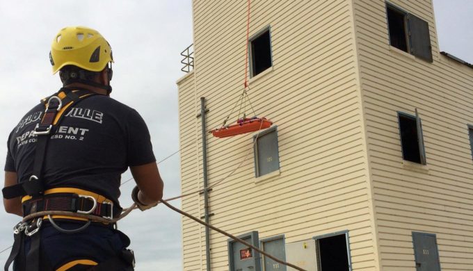 Firefighter training - Pflugerville firefighter lowering stretcher from a building